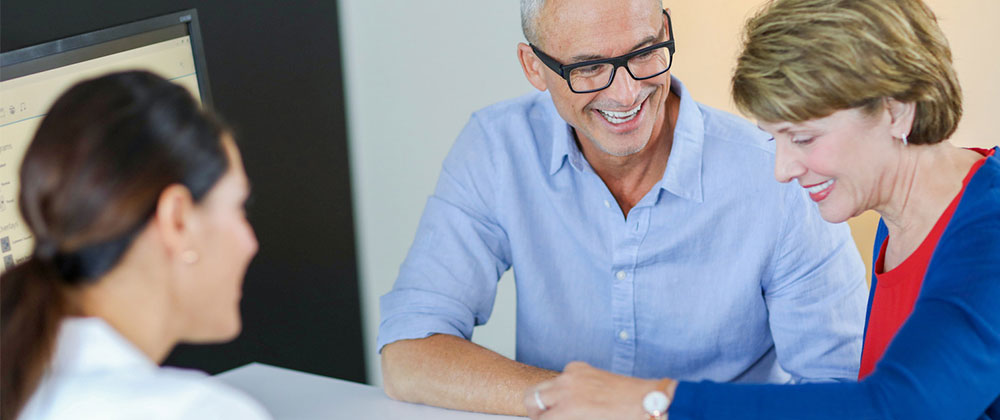 Couple in clinic laughing with professional